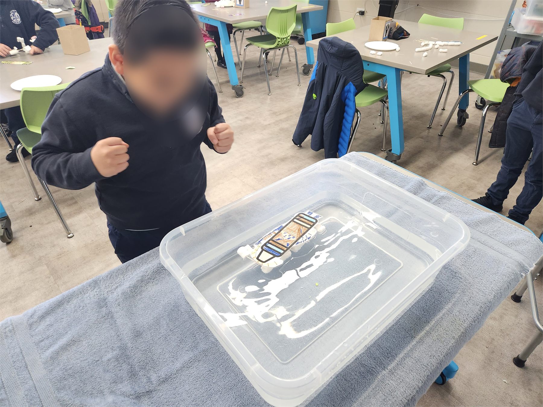 Student holding a Creepy Crayon raft over water