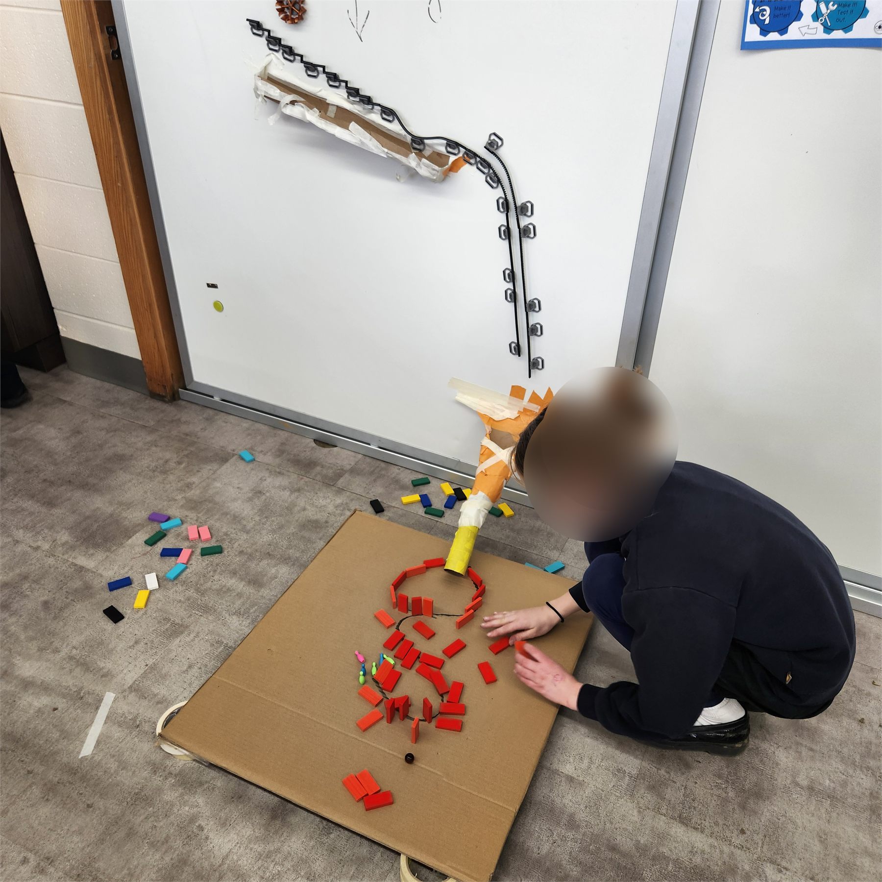 Students testing hanging elements in a Rube Goldberg machine